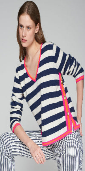 Blue and white striped sweater. V-neck. Contrasts in sleeves and collar in pink and orange. Side slits closed with gold metal buttons.

100%WOOL